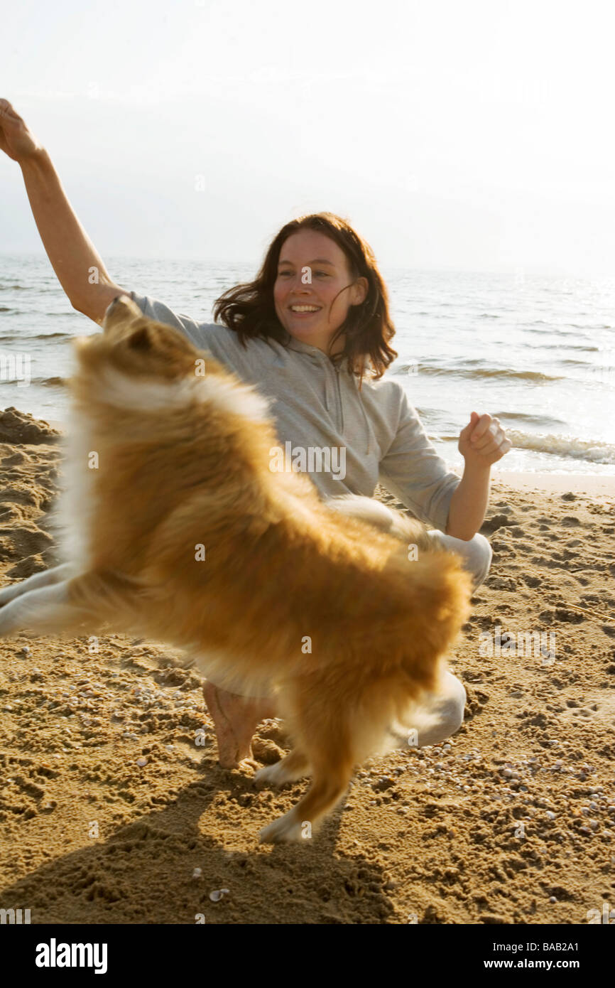 Eine Frau mit einem Hund zu Fuß am Strand, Skane, Schweden. Stockfoto