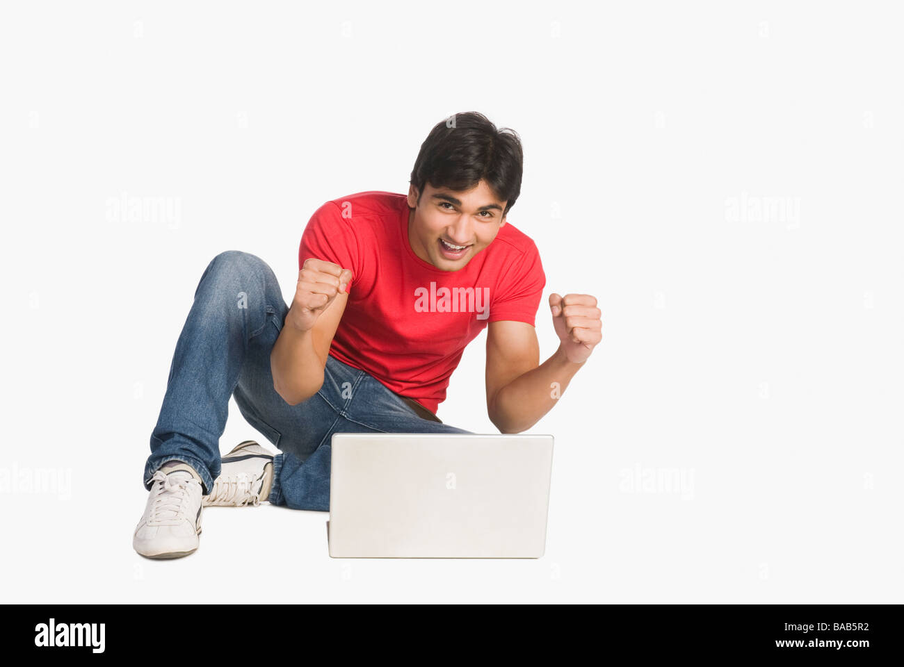 Man sitzt vor einem Laptop und lächelnd Stockfoto