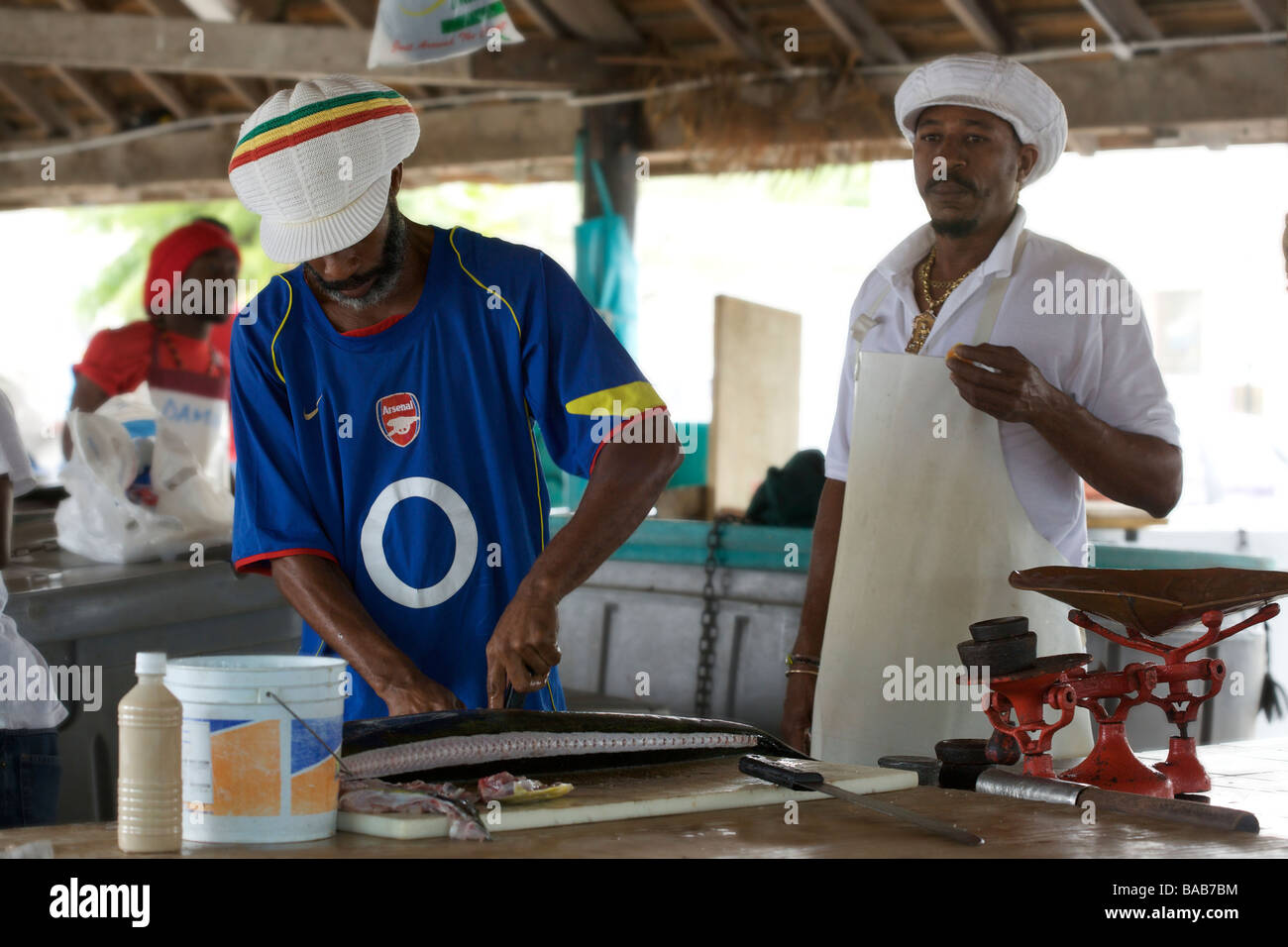 Metzger schneiden Fisch in Oistins Fish Market oder heißt jetzt Verinda Cox Fish Market, Barbados, "West Indies Stockfoto