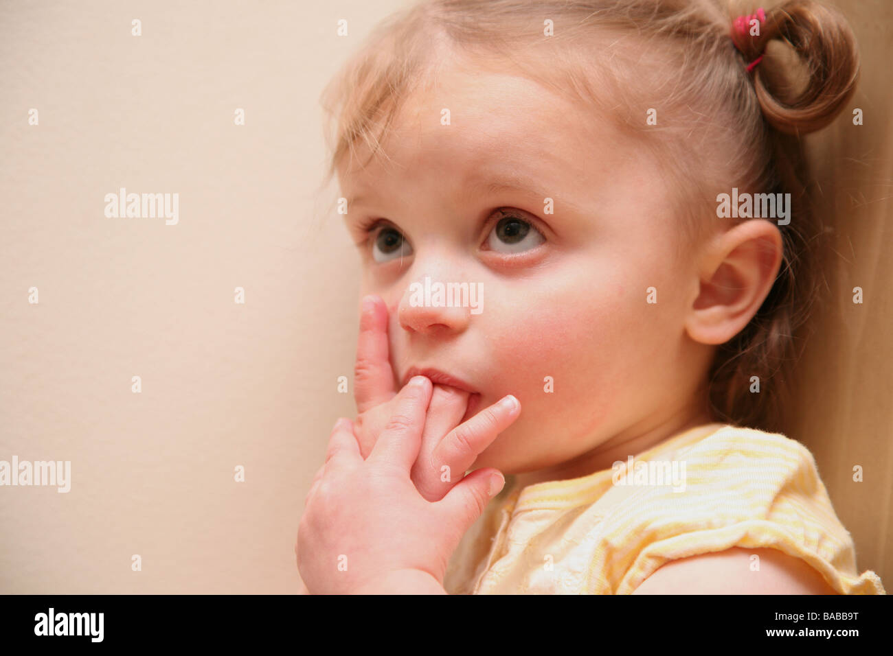 2 Jahre altes Mädchen schüchtern an Fingern saugen Stockfoto