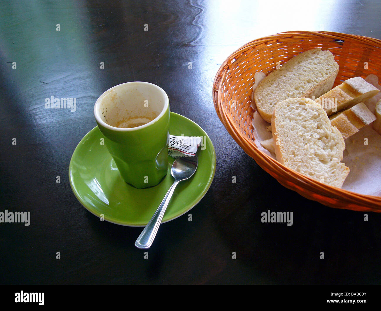 Brot in einem Brotkasten neben eine leere Tasse Espresso Stockfoto