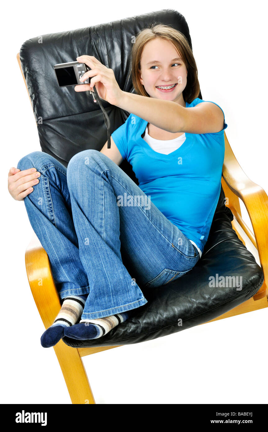 Junges Mädchen unter Bild von sich selbst im Ledersessel Stockfoto