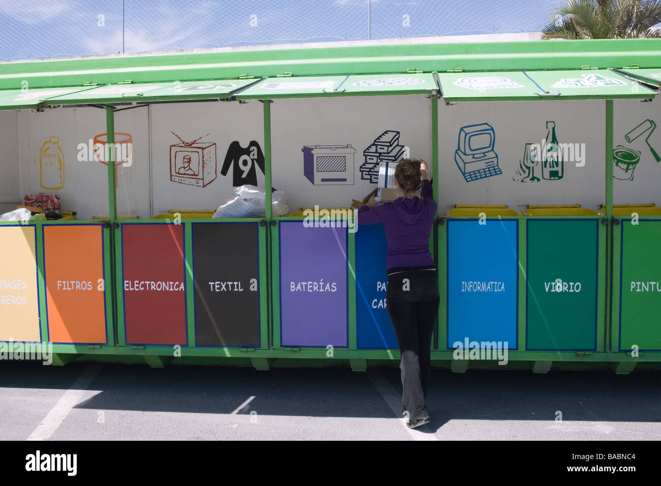 Junge Frau, die recycling-Kartons an mobile recycling-Einheit in Torremolinos Malaga Spanien Stockfoto