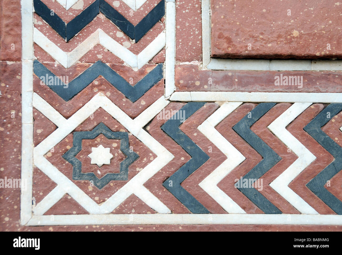Wiederholt Zickzackmuster wo farbigen Steinen eingelegten Sandstein Pflastersteine in einem Innenhof haben.  Taj Mahal, Agra, Uttar Stockfoto