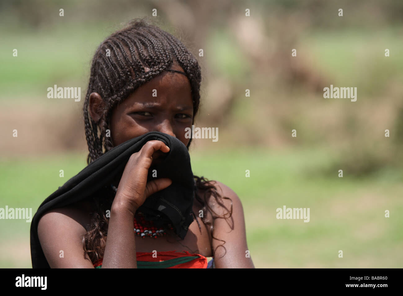 Ein junge äthiopische Mädchen verbirgt ihr Gesicht in Anwesenheit von fremden Stockfoto