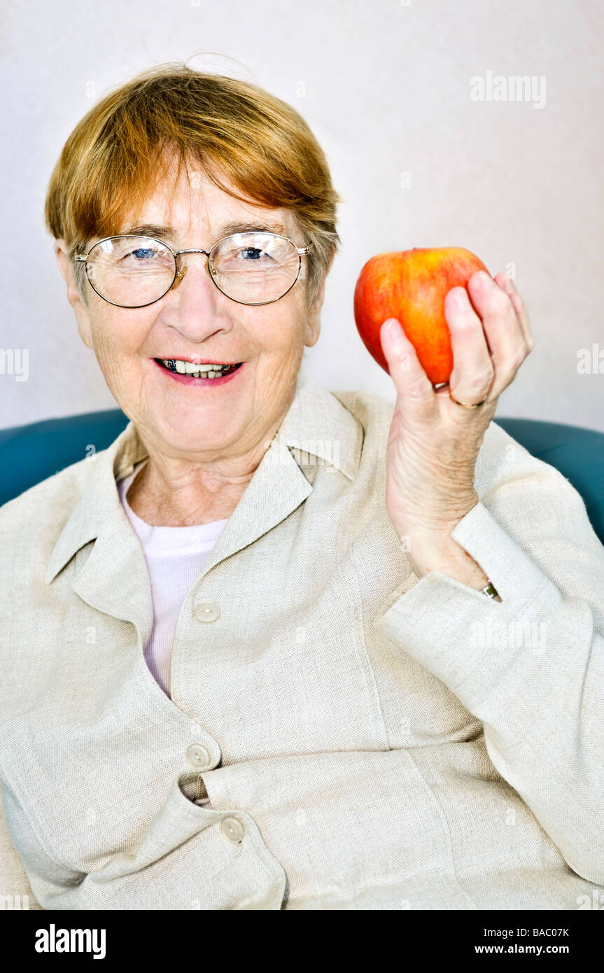 Ältere Frau Essen gesund hält einen nahrhaften Apfel Stockfoto