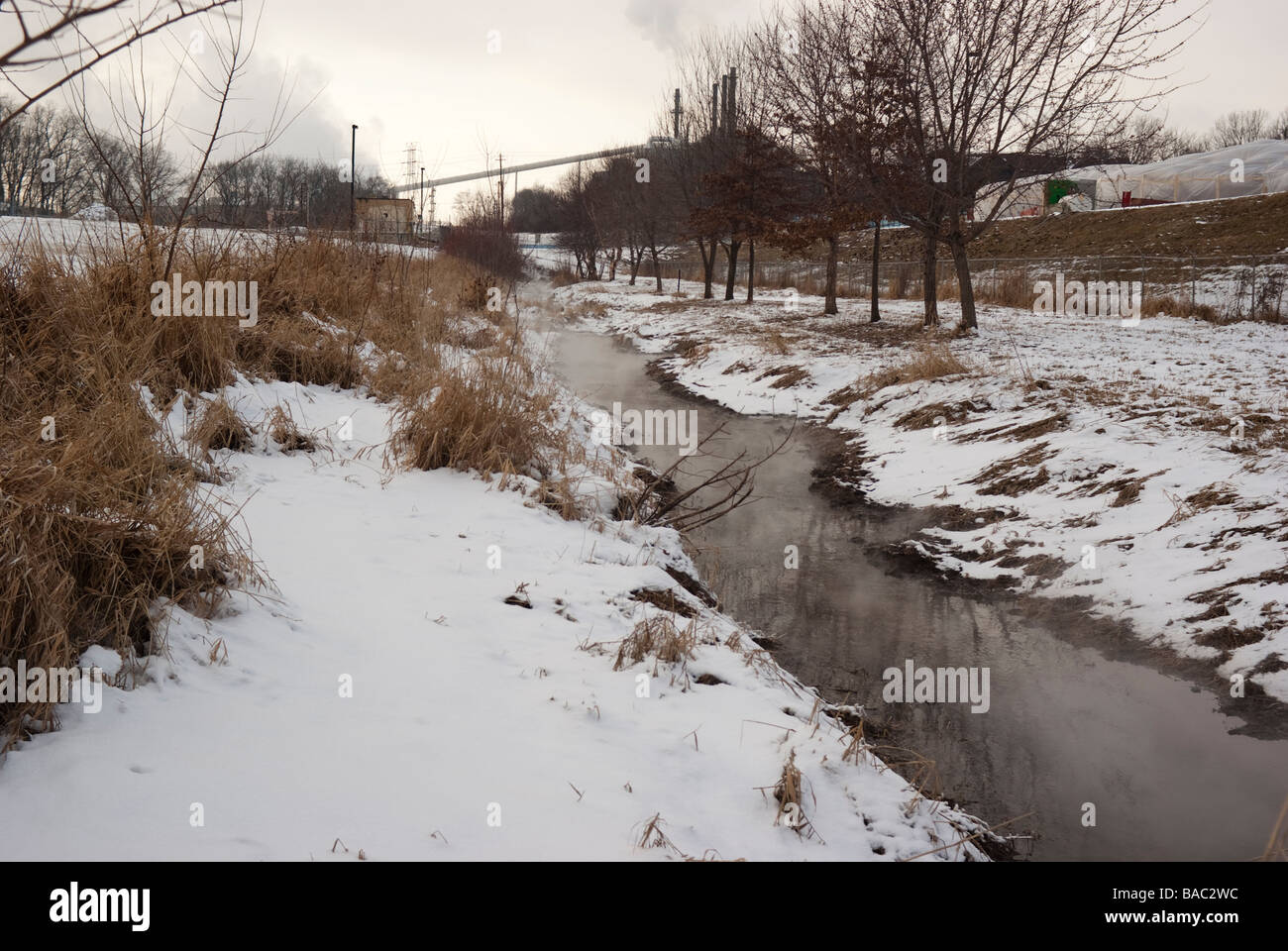 Ein dampfender Stream des aufbereiteten Abwassers führt weg von der Kläranlage und in Richtung des Flusses in West Lafayette, Indiana Stockfoto