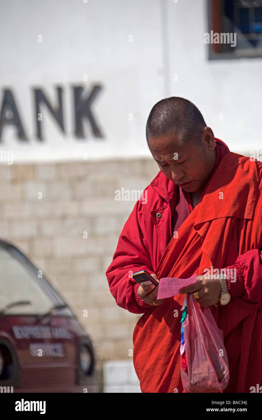 Bhutan Mann SMS auf Handy außerhalb Bank in Thimphu Bhutan Asien 91005 Bhutan-Thimphu vertikal Stockfoto