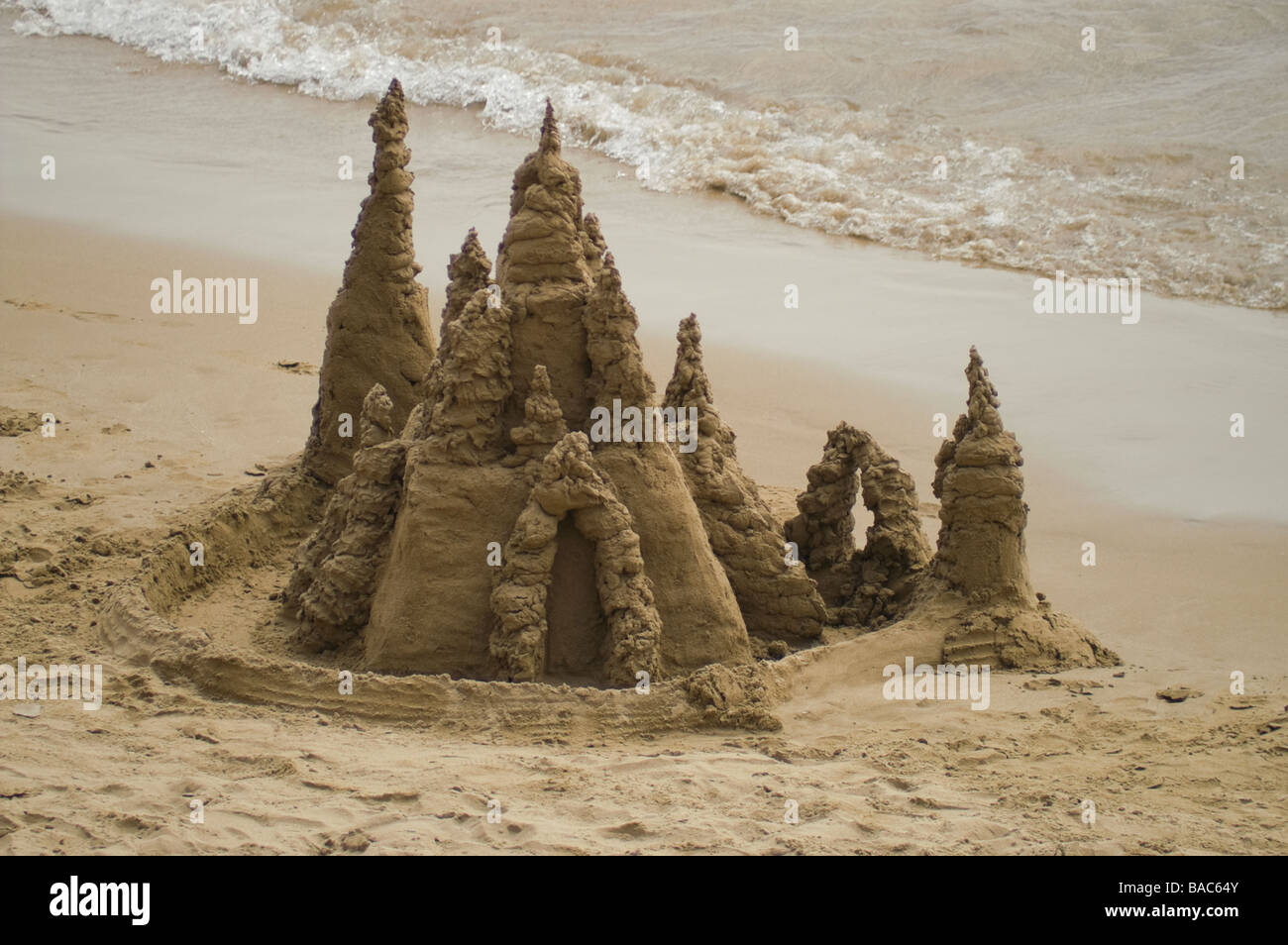 Komplizierte Sandburg am Meer mit Wellen Stockfoto