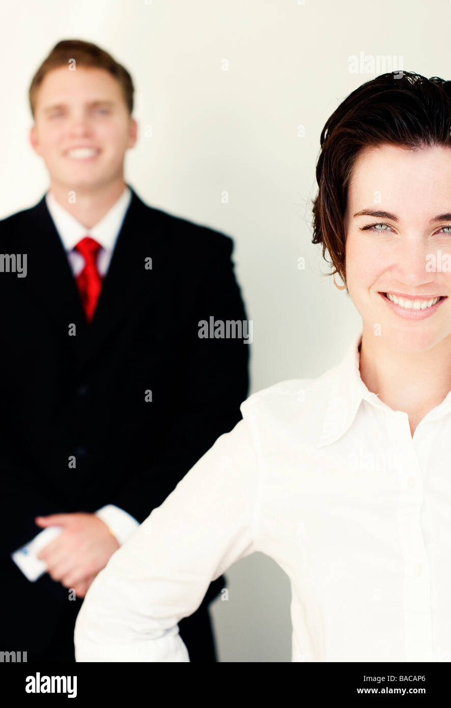 Business-Mann im schwarzen Anzug und Krawatte steht hinter lächelnde Frau in weißen Kleidern Stockfoto