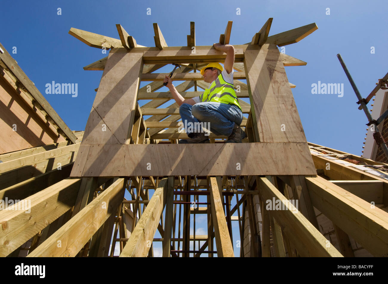 Ein Baumeister arbeiten auf dem Dach eines neuen Hauses Stockfoto