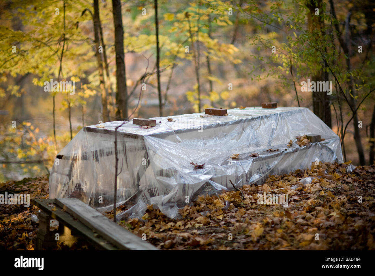 Picknick-Tisch in den Wäldern bedeckt aus Kunststoff zum Schutz Stockfoto
