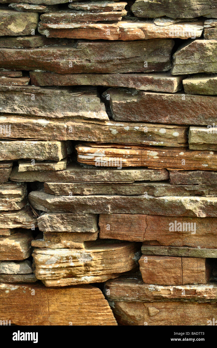 Trockenen Steinmauer in der Frühlingssonne mit Flechten und Eisen Puigment im Stein Stockfoto