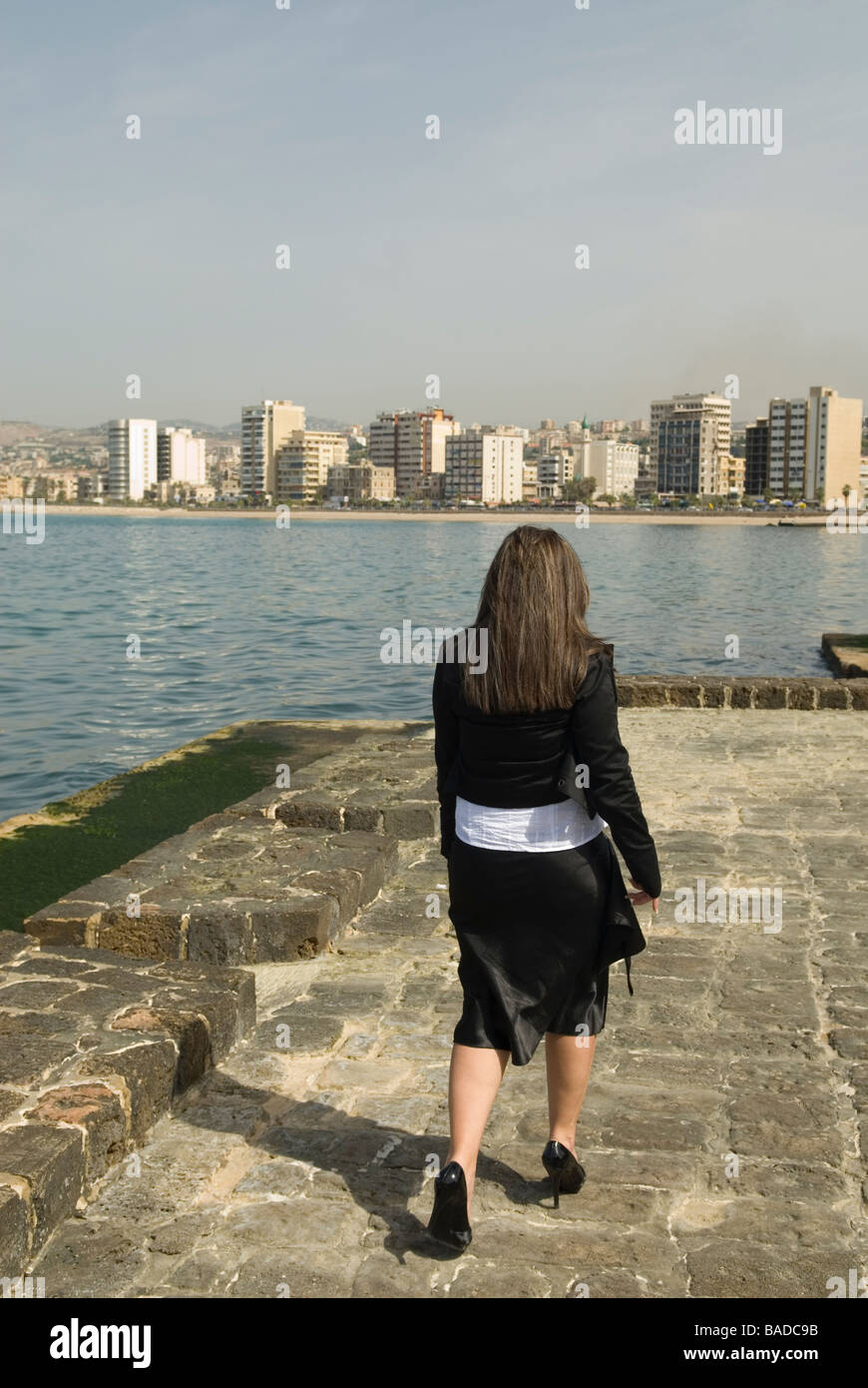 Rückansicht des eine Geschäftsfrau zu Fuß am Meer Stockfoto