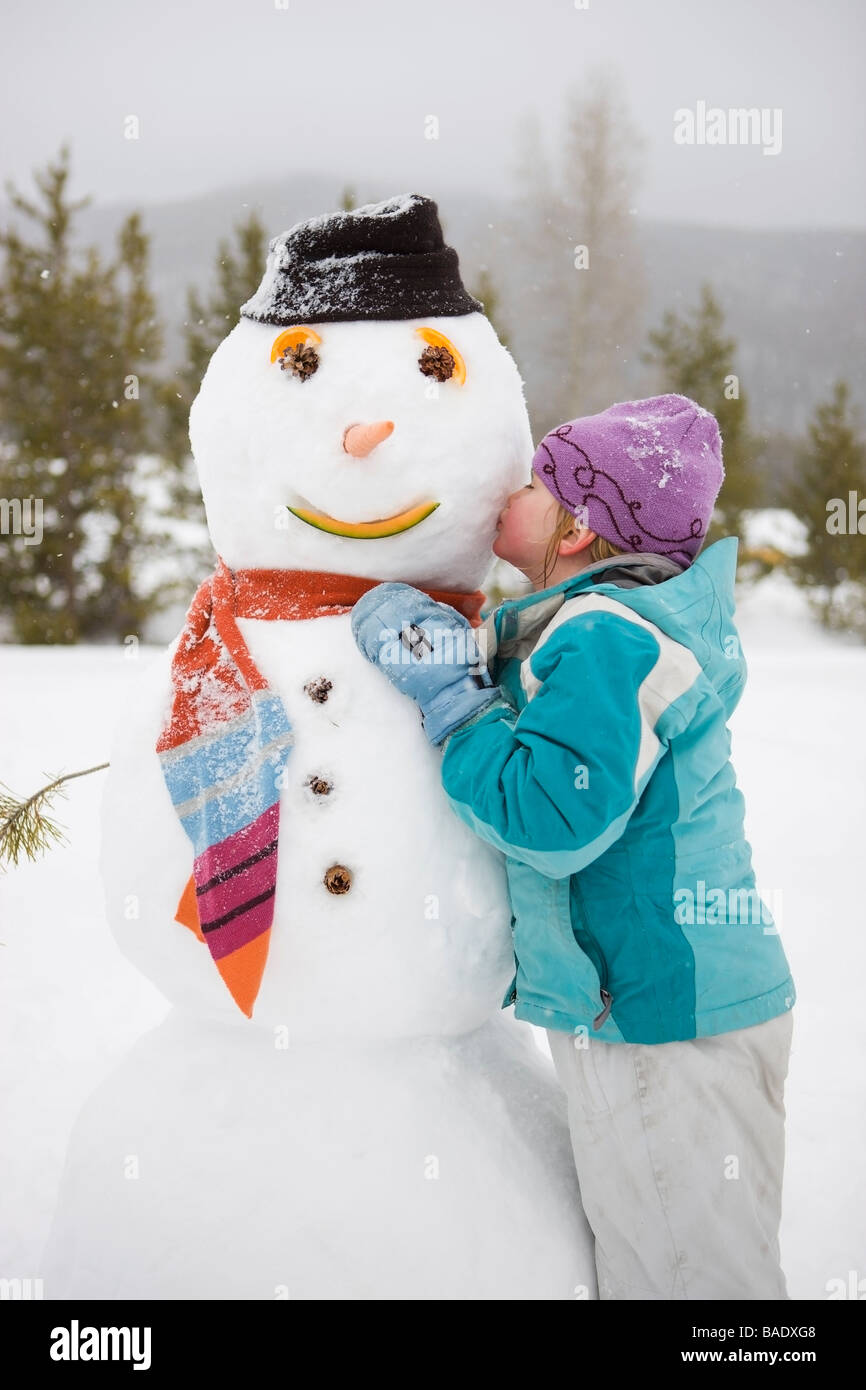 Mädchen küssen Schneemann, in der Nähe von Frisco, Summit County, Colorado, USA Stockfoto