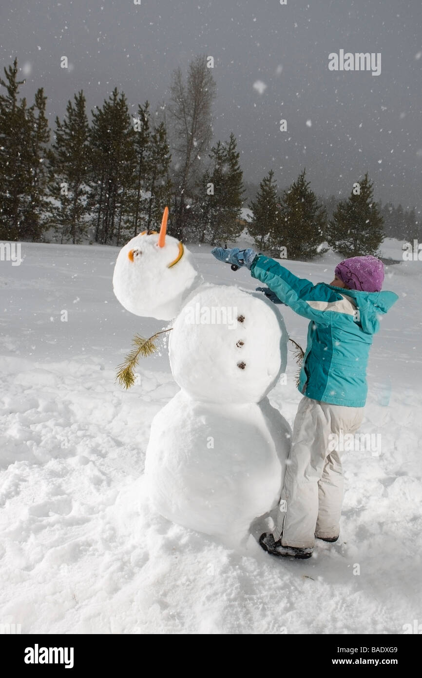 Mädchen schob den Kopf Schneemann, Summit County, in der Nähe von Frisco, Colorado, USA Stockfoto