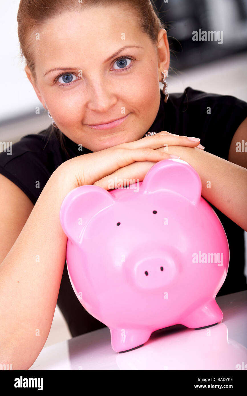 schöne Geschäftsfrau mit einem Sparschwein zu Hause Stockfoto