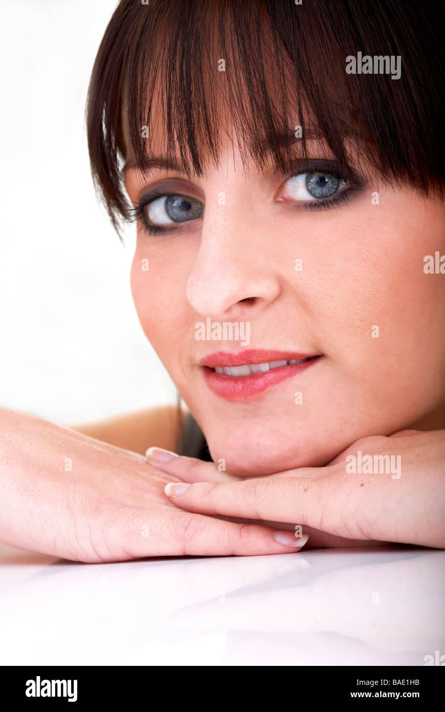 Lässige Frau Porträt auf dem Boden lächelnd - auf einem weißen Hintergrund isoliert Stockfoto