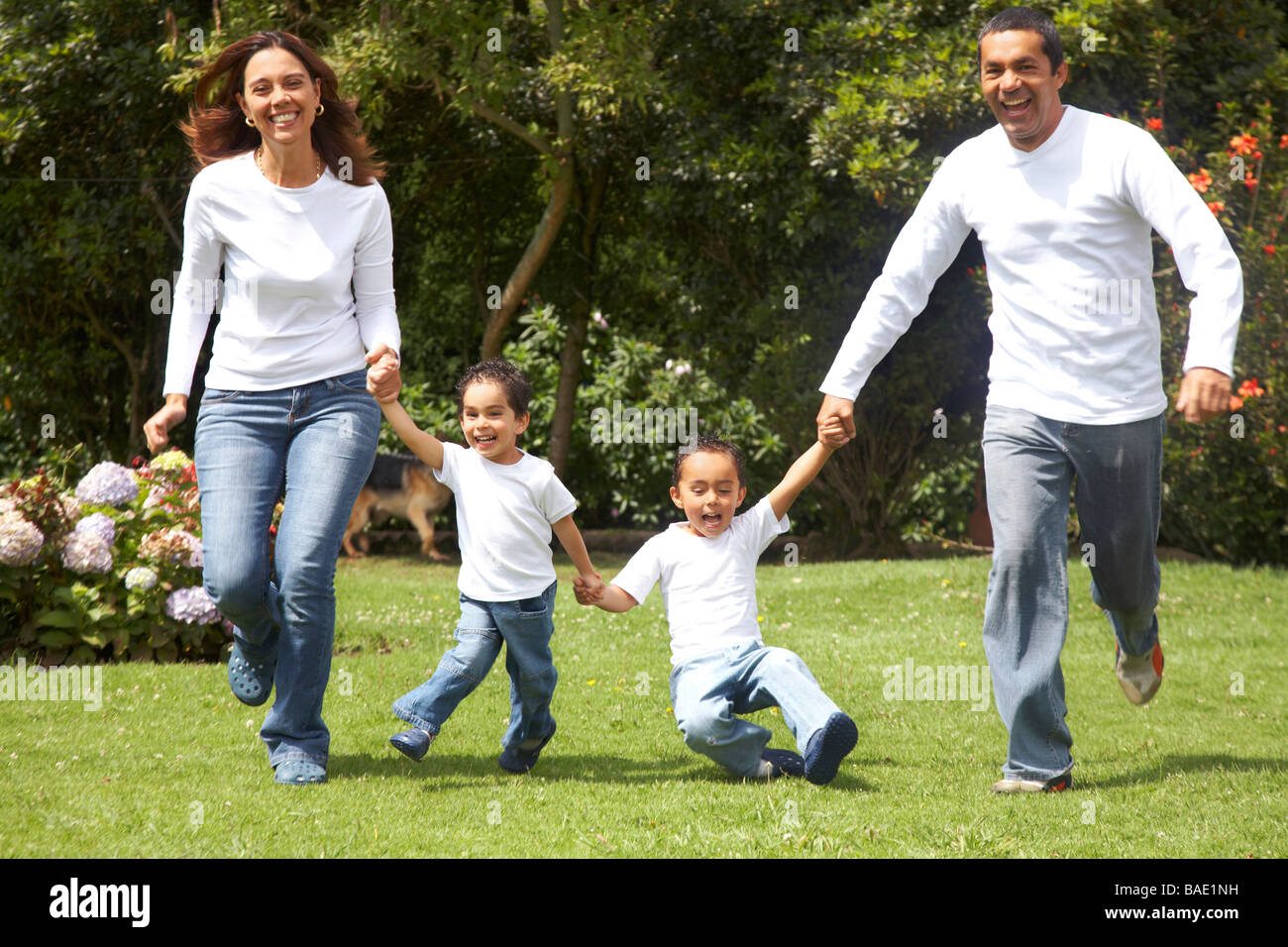 Familie Spaß mit Eltern und ihren zwei Kindern im freien laufen Stockfoto