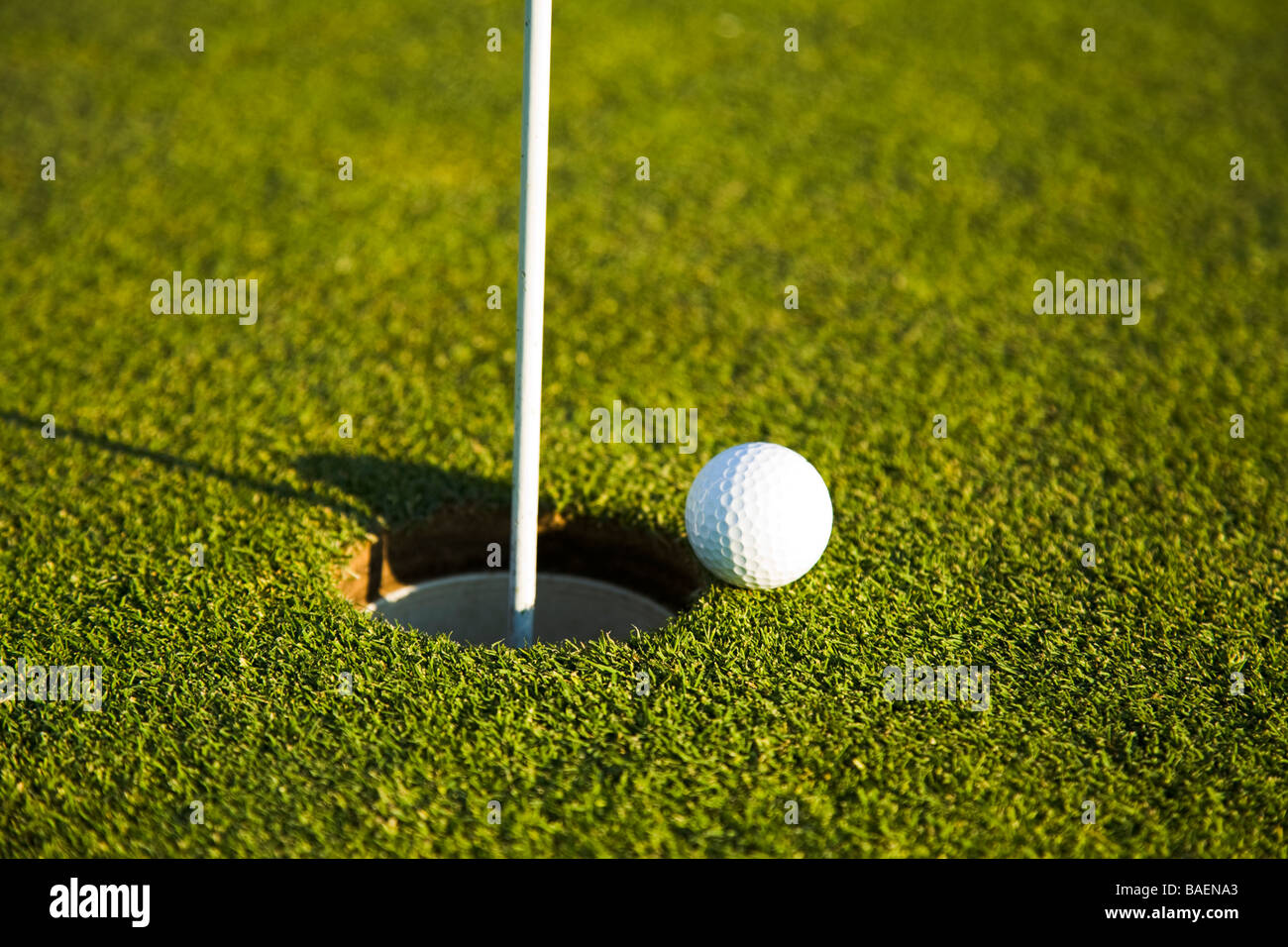 GOLF Golfball am Rand des Loch Pin und Flagge Stockfoto