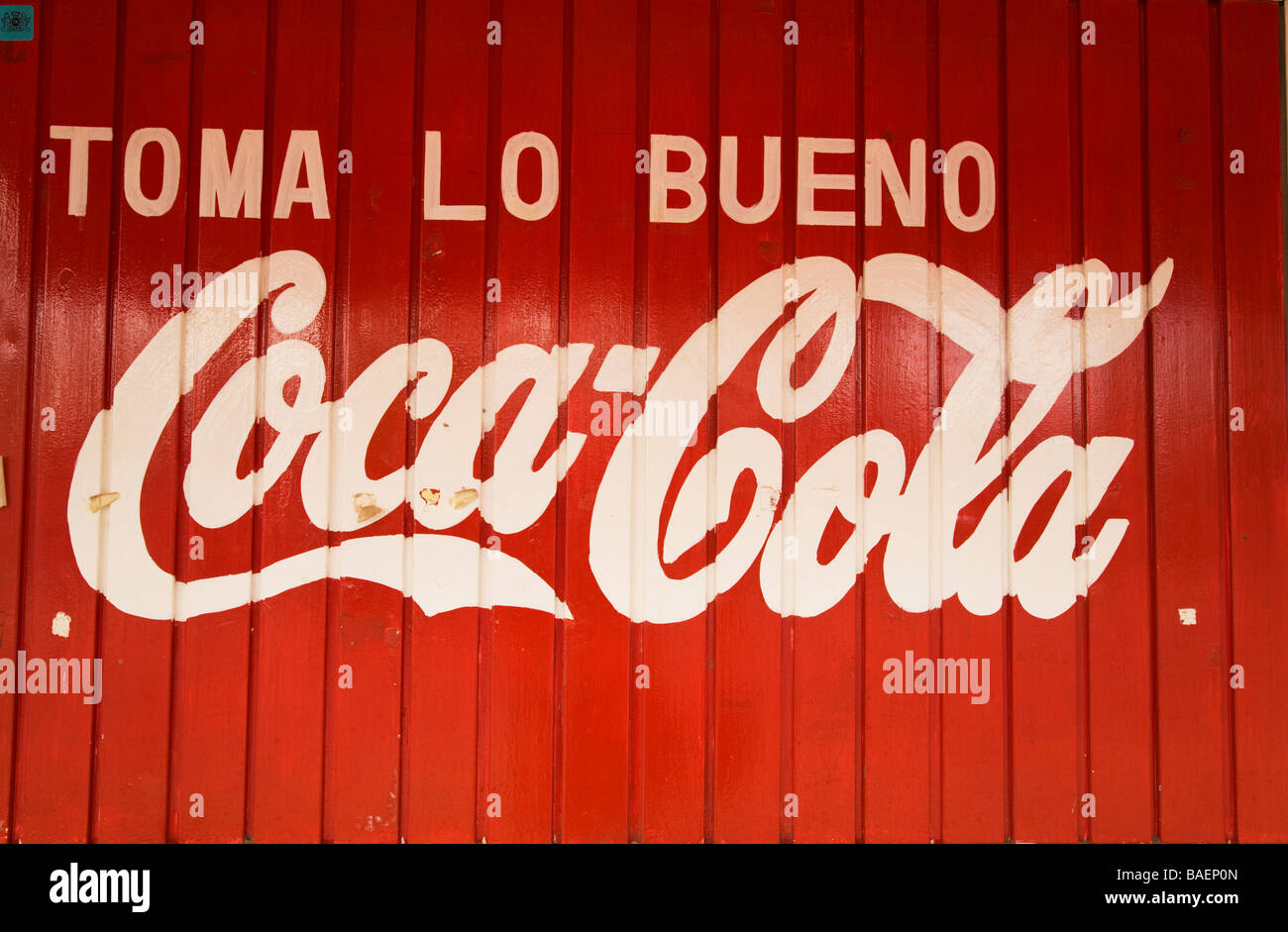 Mexiko Todos Santos Werbung für Coca Cola in spanischer Sprache gemalt auf der roten Holzgebäude Toma lo Bueno Motto Stockfoto