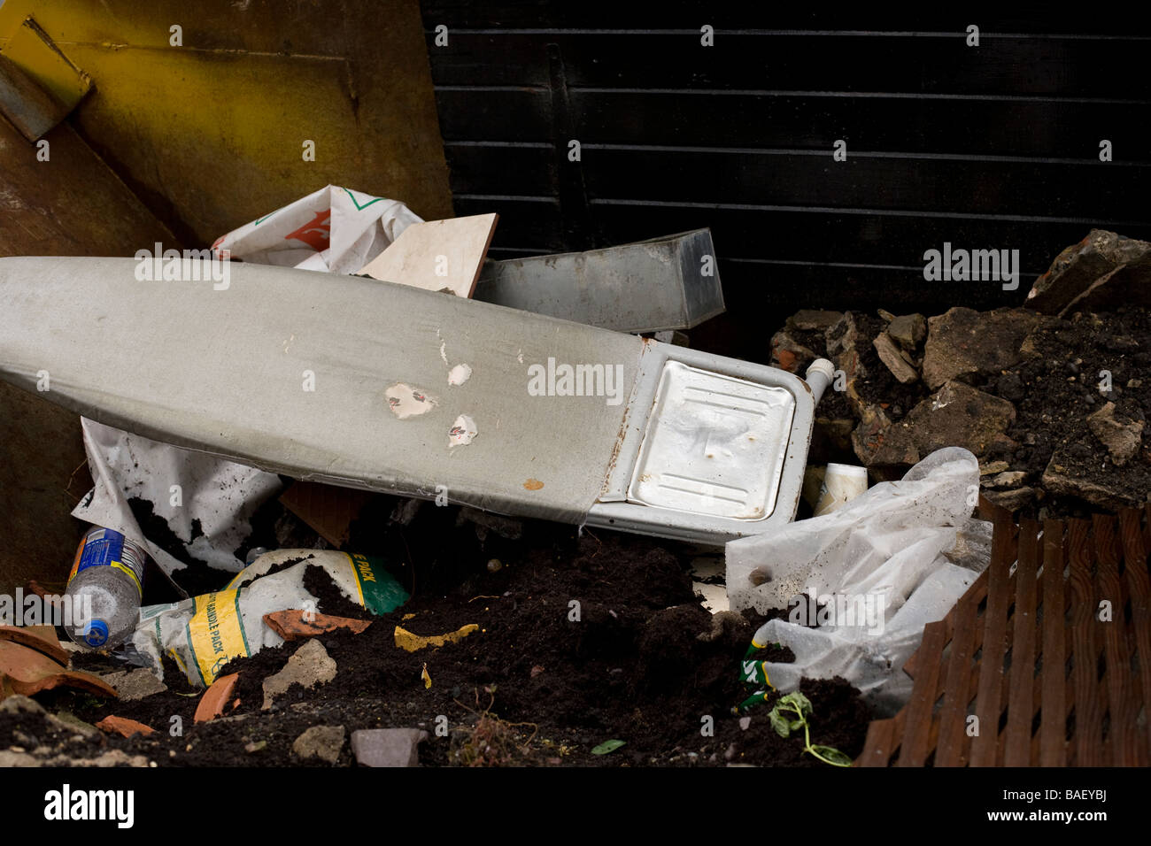 Ein Bügeleisen /-Brett in ein überspringen voller Baumaterialien geworfen Stockfoto