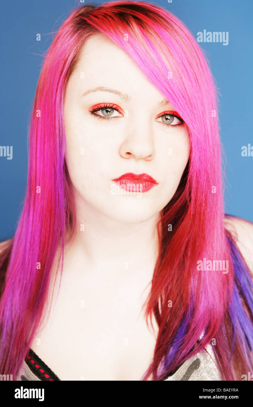 Junge Teen mit leuchtend rosa Haaren und roten Lippen Blick direkt in die Kamera Stockfoto