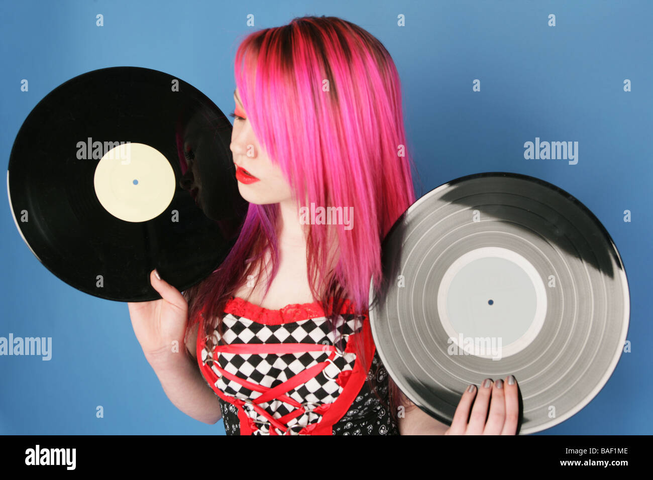 Junge Cyber zeichnet Goth mit leuchtend rosa Haaren 12 Inch Vinyl hält in jeder hand Stockfoto