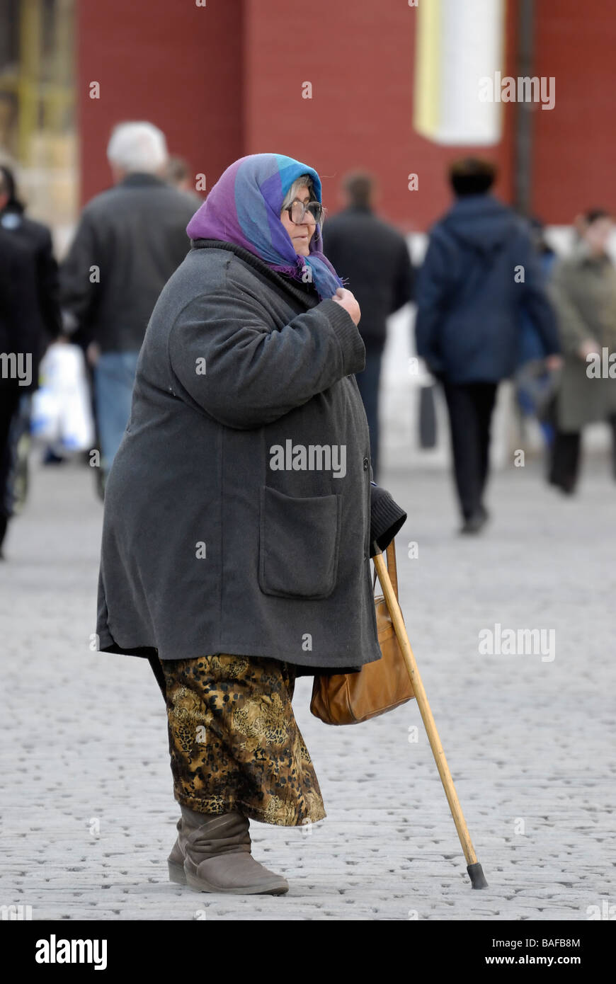 Alte Frau wirft vor der russischen Kirche in der Nähe der Roten Platz in Moskau Stockfoto