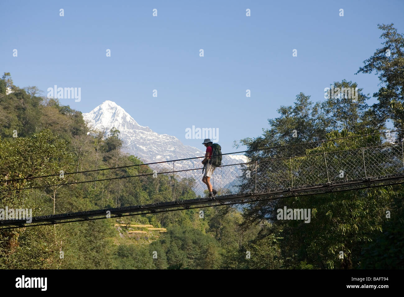 Trekker kreuzt eine Drehbrücke über den Modi Khola auf dem Weg in die Annapurna Sanctuary Stockfoto