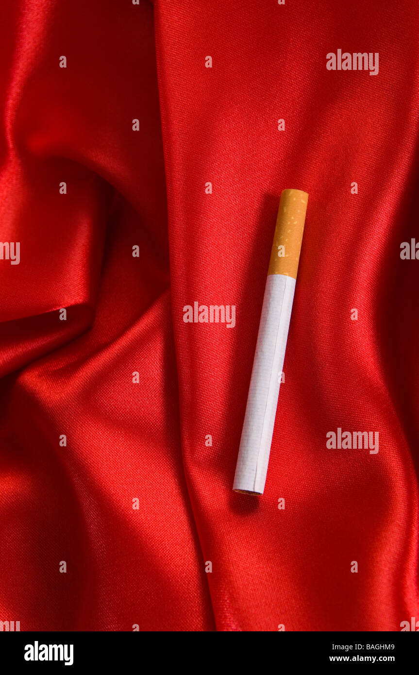 Eine Zigarette auf roter Seide Stockfoto