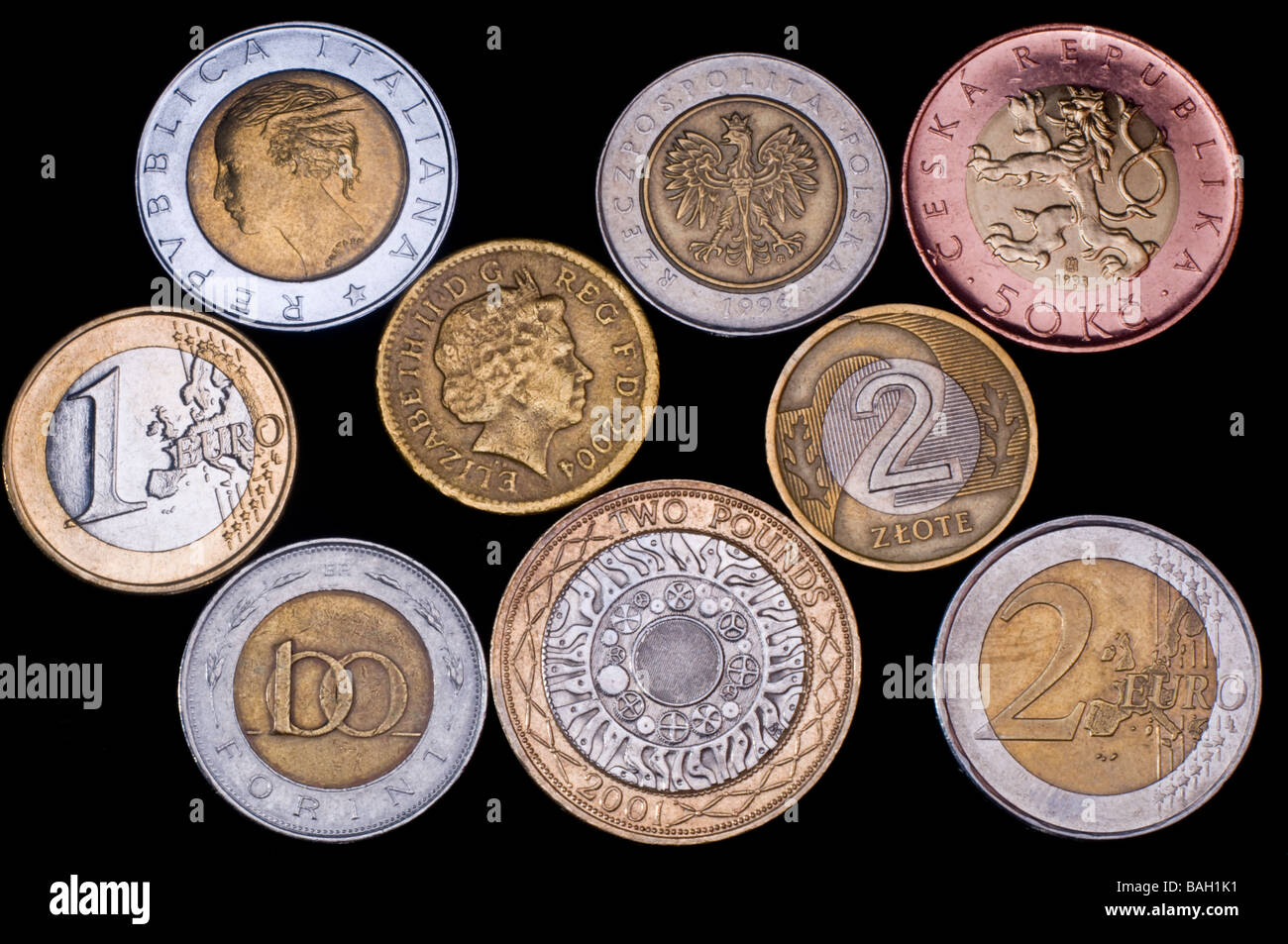 Bimetall-Münzen aus der Eurozone, Polen, Ungarn, Tschechien und Italien (vor Euro) mit gefälschten britischen Pfund-Münze Stockfoto
