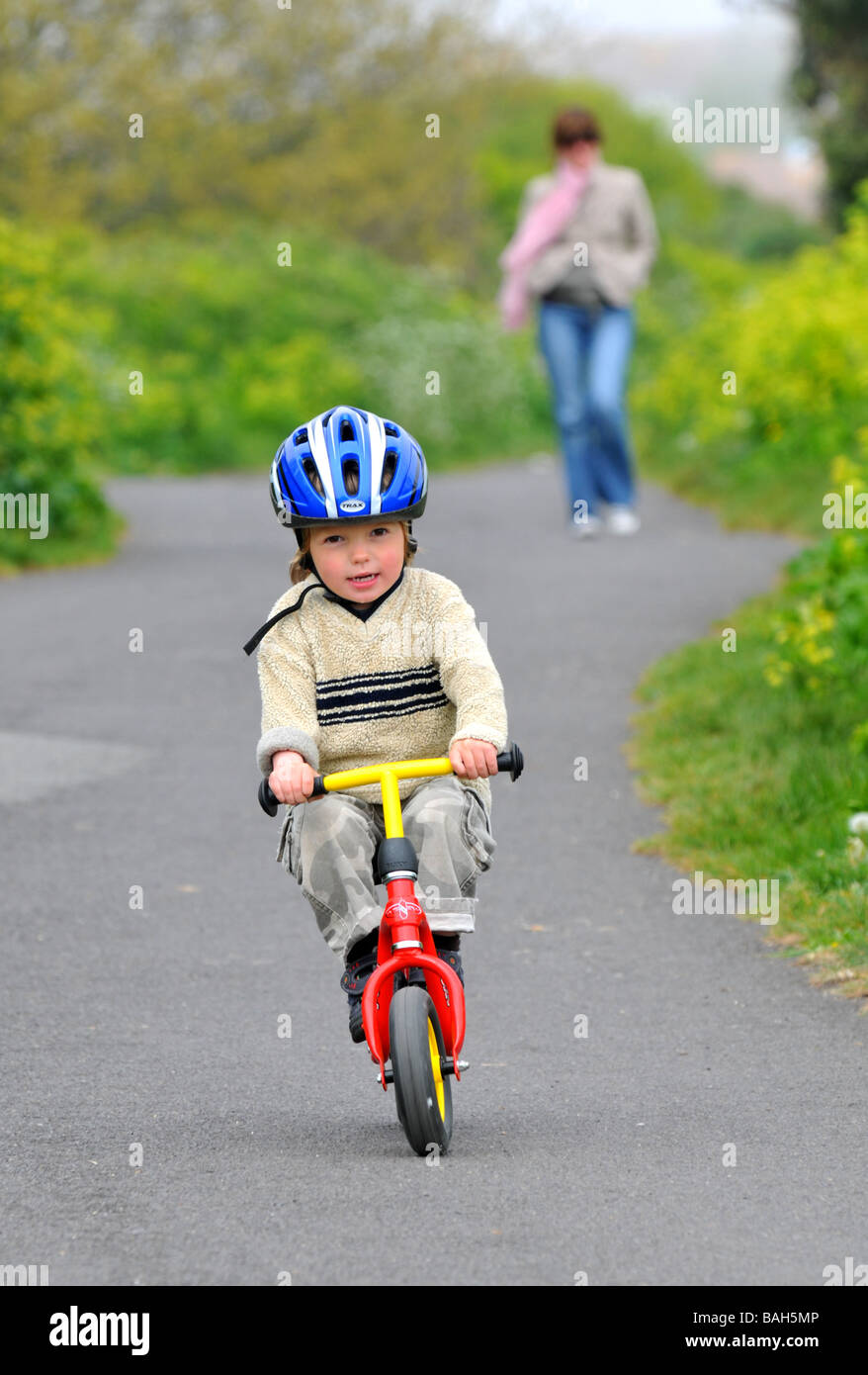 Junge mit dem Balance-Fahrrad fahren lernen Stockfoto