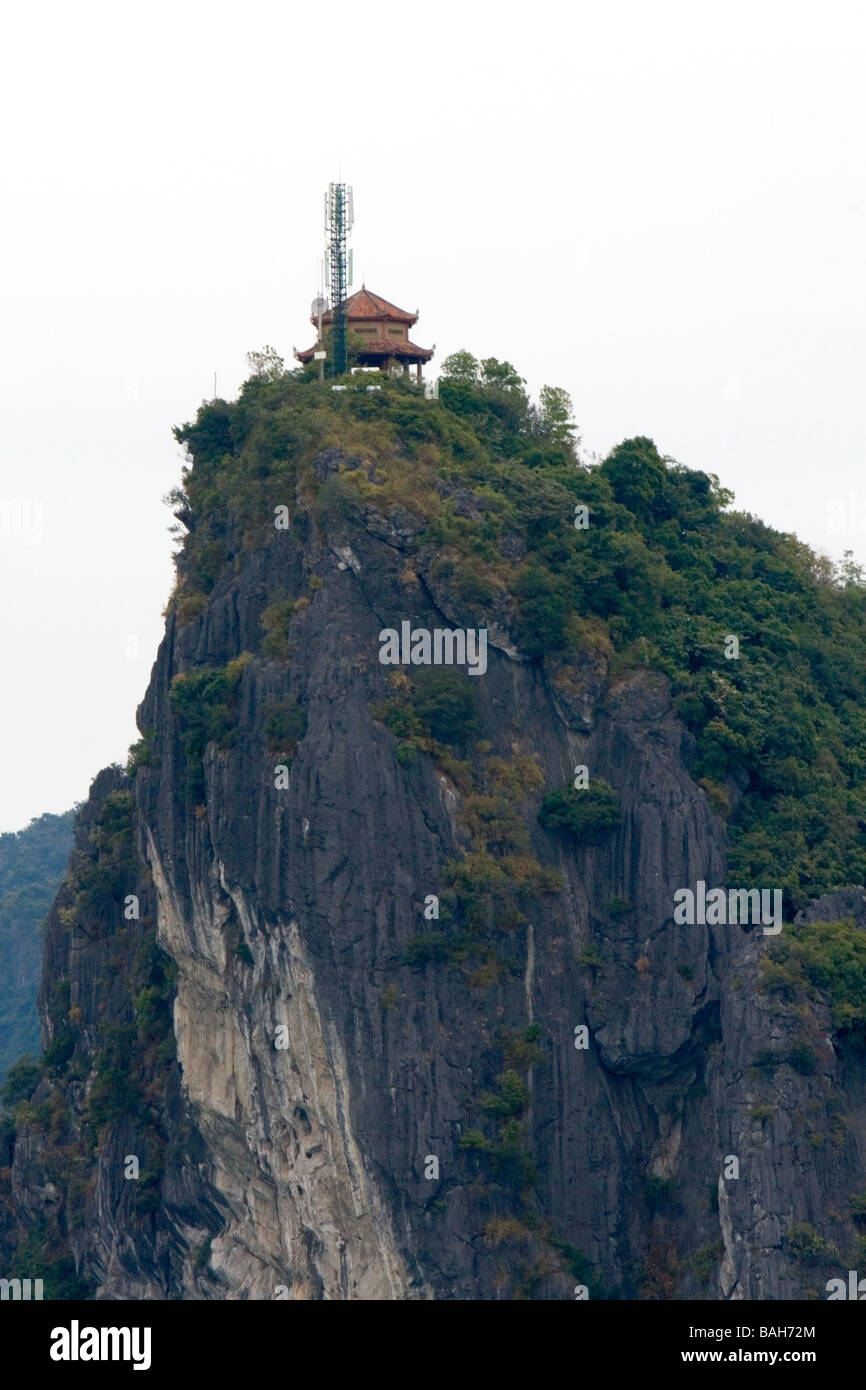 Kalkstein-Kriterium, garniert mit einer alten Struktur und moderne Handy-Turm in Ha Long Bay Vietnam Stockfoto