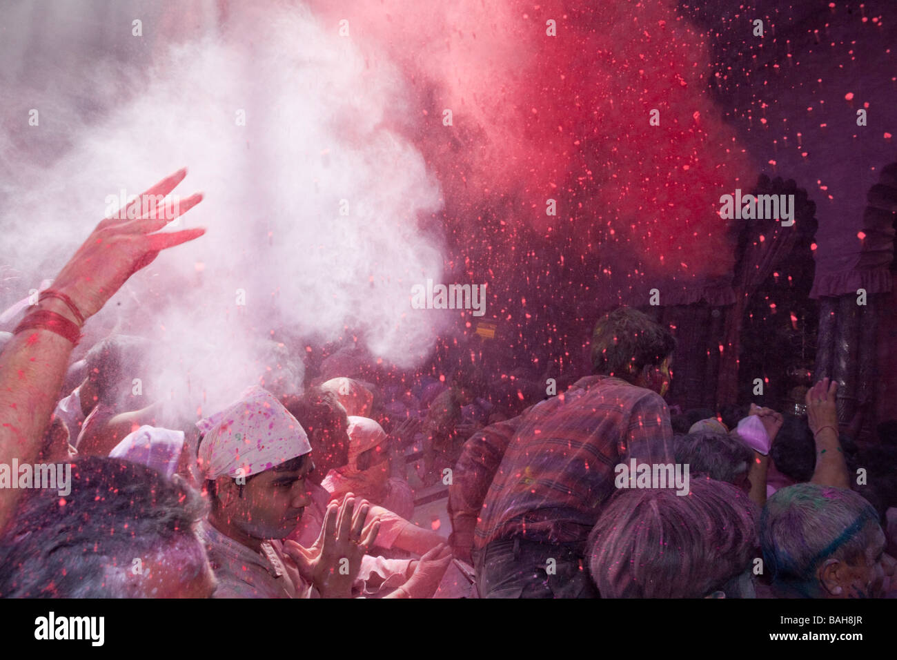 Menschen werfen Farbpulver In einem Hindu-Tempel im indischen Holi Festival Mathura Stockfoto