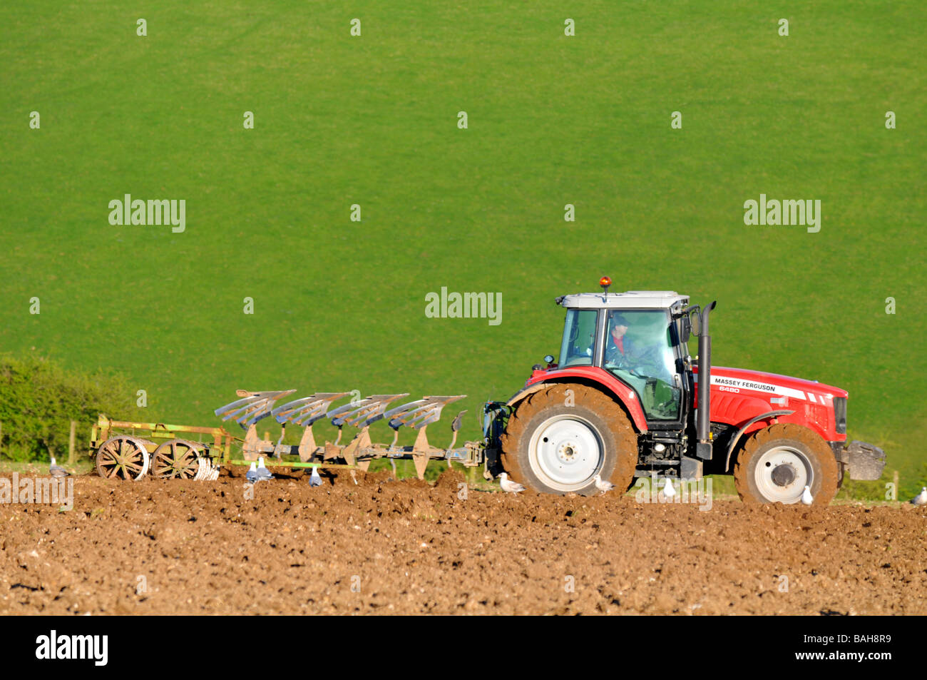 Traktor pflügen ein Feld in Großbritannien UK Stockfoto