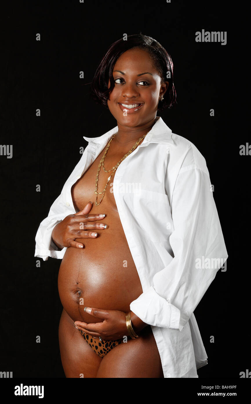 ziemlich schwanger schwarze Mädchen auf einem schwarzen Hintergrund Stockfoto