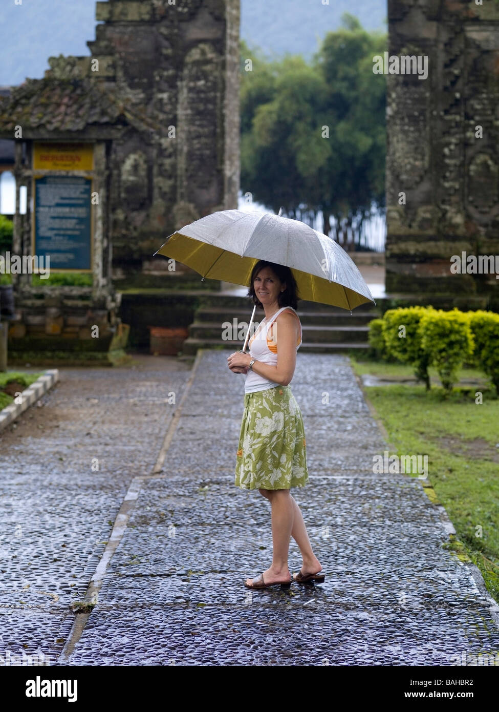 Ulun Danu Tempel Bali Indonesien; Frau im Regen Stockfoto