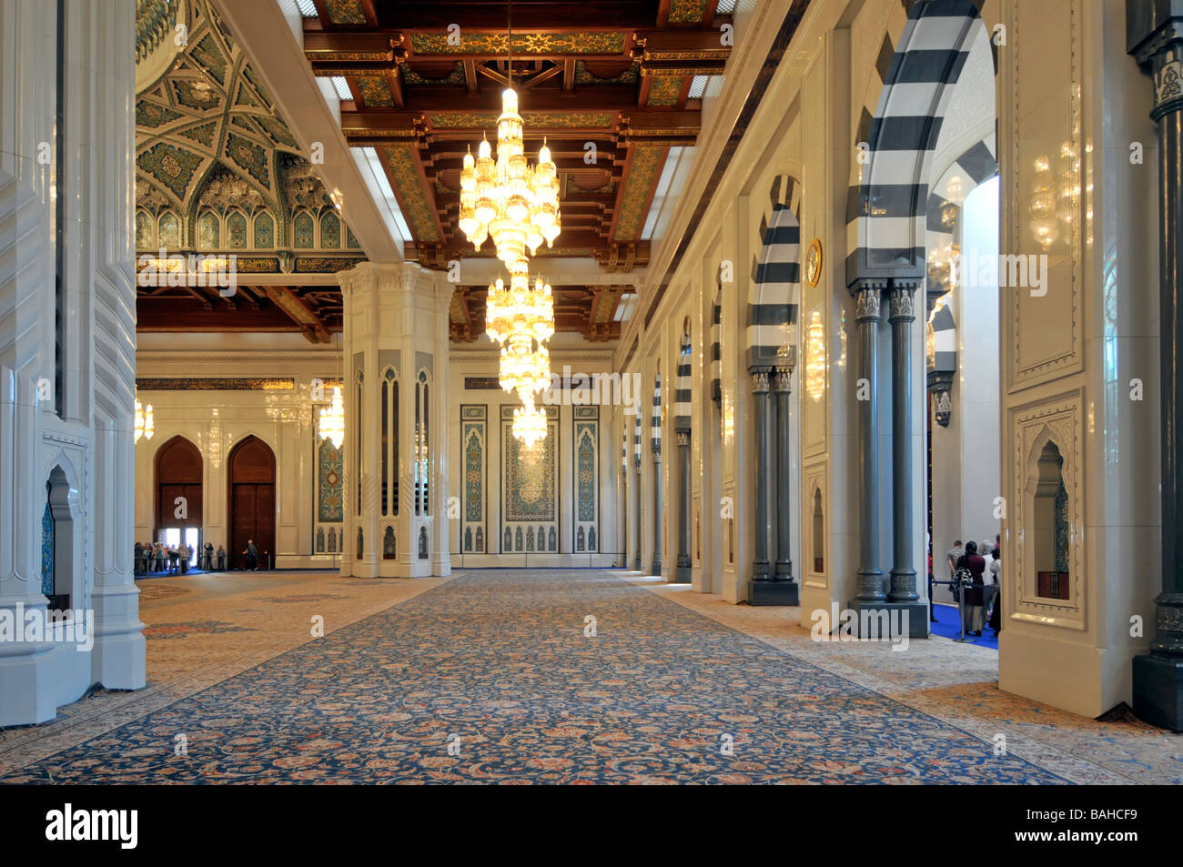 Muscat-Oman-Moschee innen mit Teppich ausgelegten Gebetsraum mit Kronleuchtern und reich verzierte Decke Stockfoto