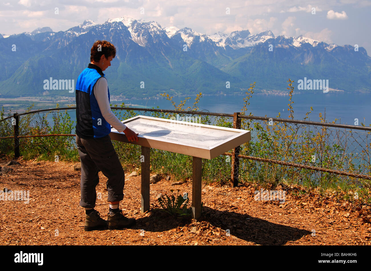 Eine weibliche Wanderer mit Blick auf eine Informationstafel am Aussichtspunkt hoch über dem See Leman, Les Avants Waadt Ausrüstu Le Cubly belvédère Stockfoto