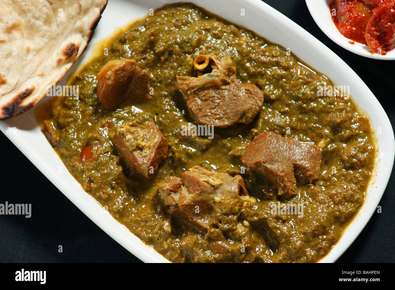Saag Hammelfleisch wird hergestellt aus Hammelfleisch in Palak Soße (Spinat) und indischen Gewürzen gekocht & mit Roti & Pickle serviert Stockfoto