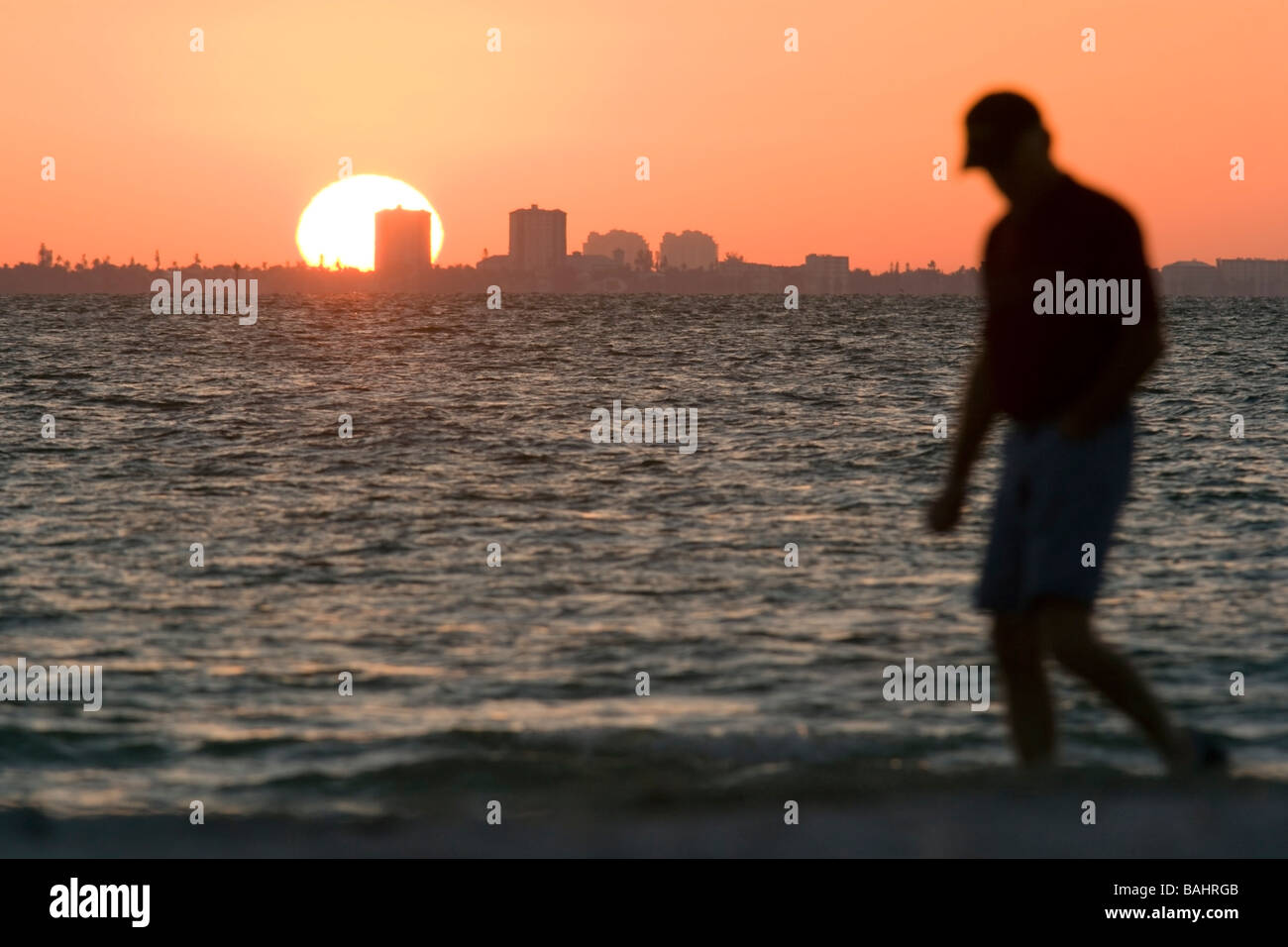 Mann zu Fuß am Strand bei Sonnenaufgang - Sanibel Island, Florida Stockfoto