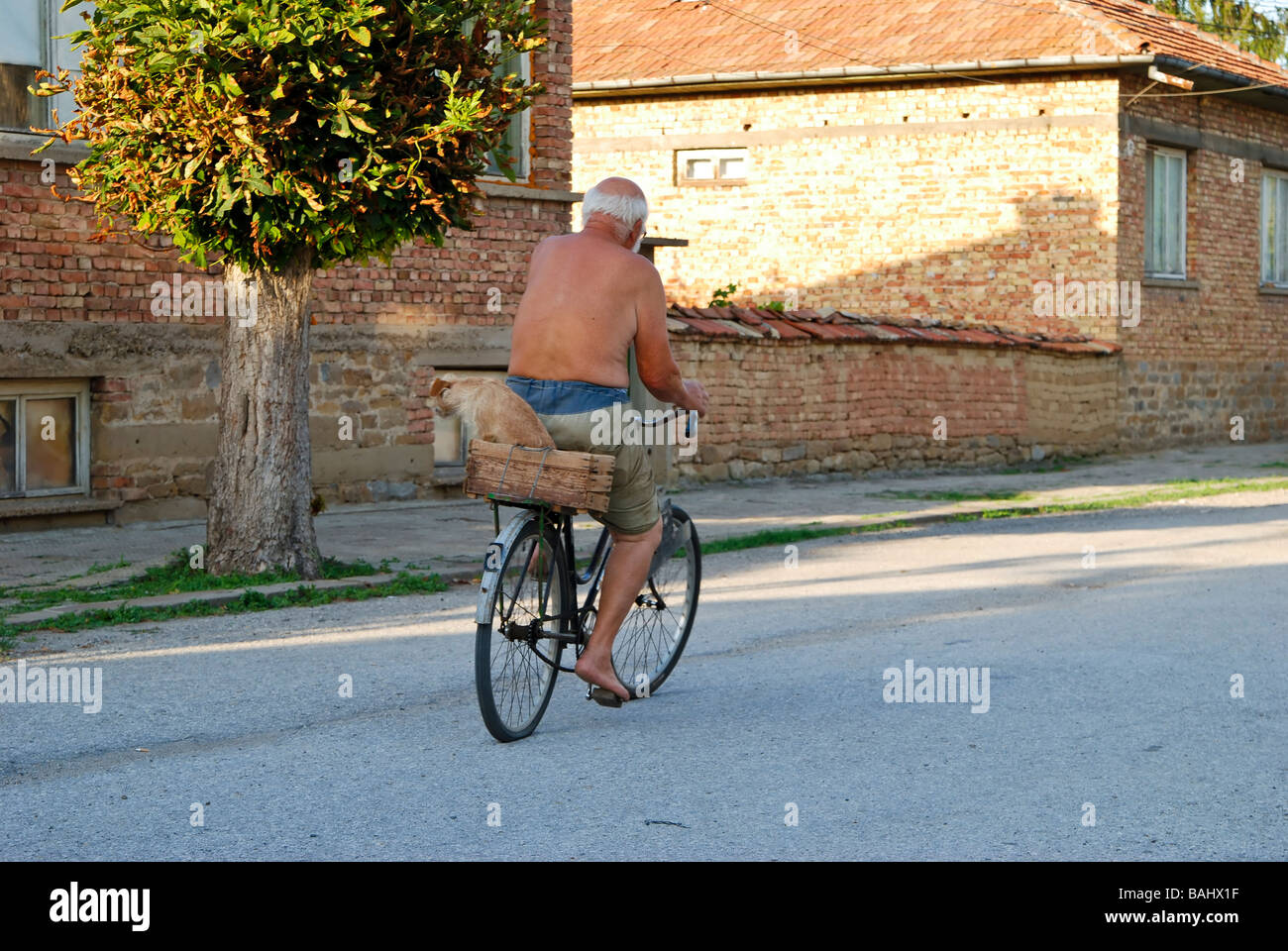 Dorfbewohner und ein Hund auf dem Fahrrad. Stockfoto