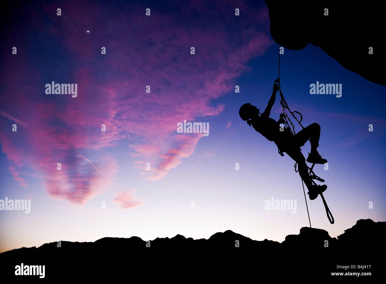 Ein Bergsteiger baumelt in der Luft, wie sie vom Gipfel des einen Rock-Turm Abseilung Stockfoto