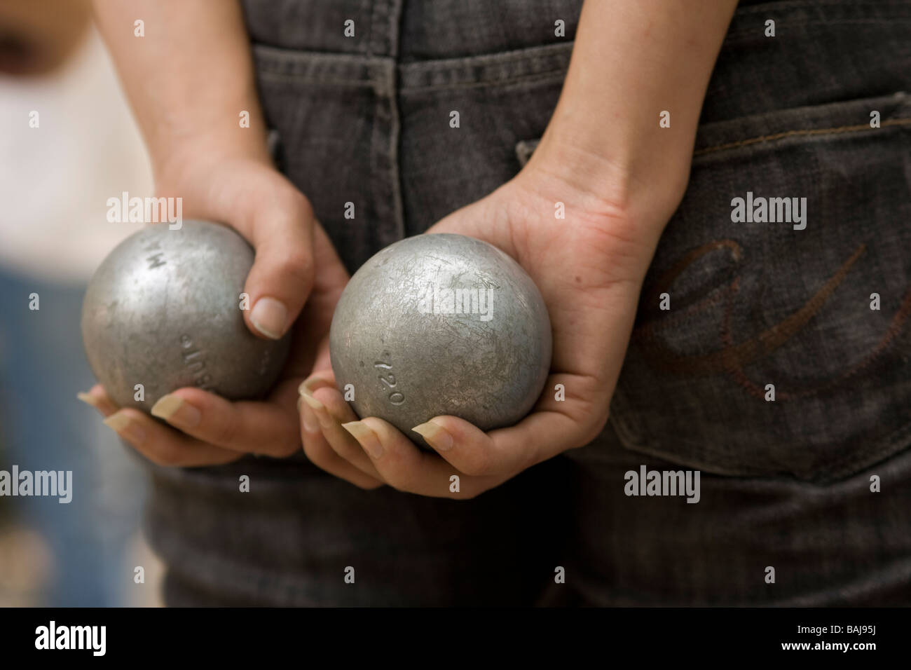 Eine Frau hält Petanque Kugeln während des Wartens ihrerseits im Bryant Park in New York City zu werfen. Stockfoto