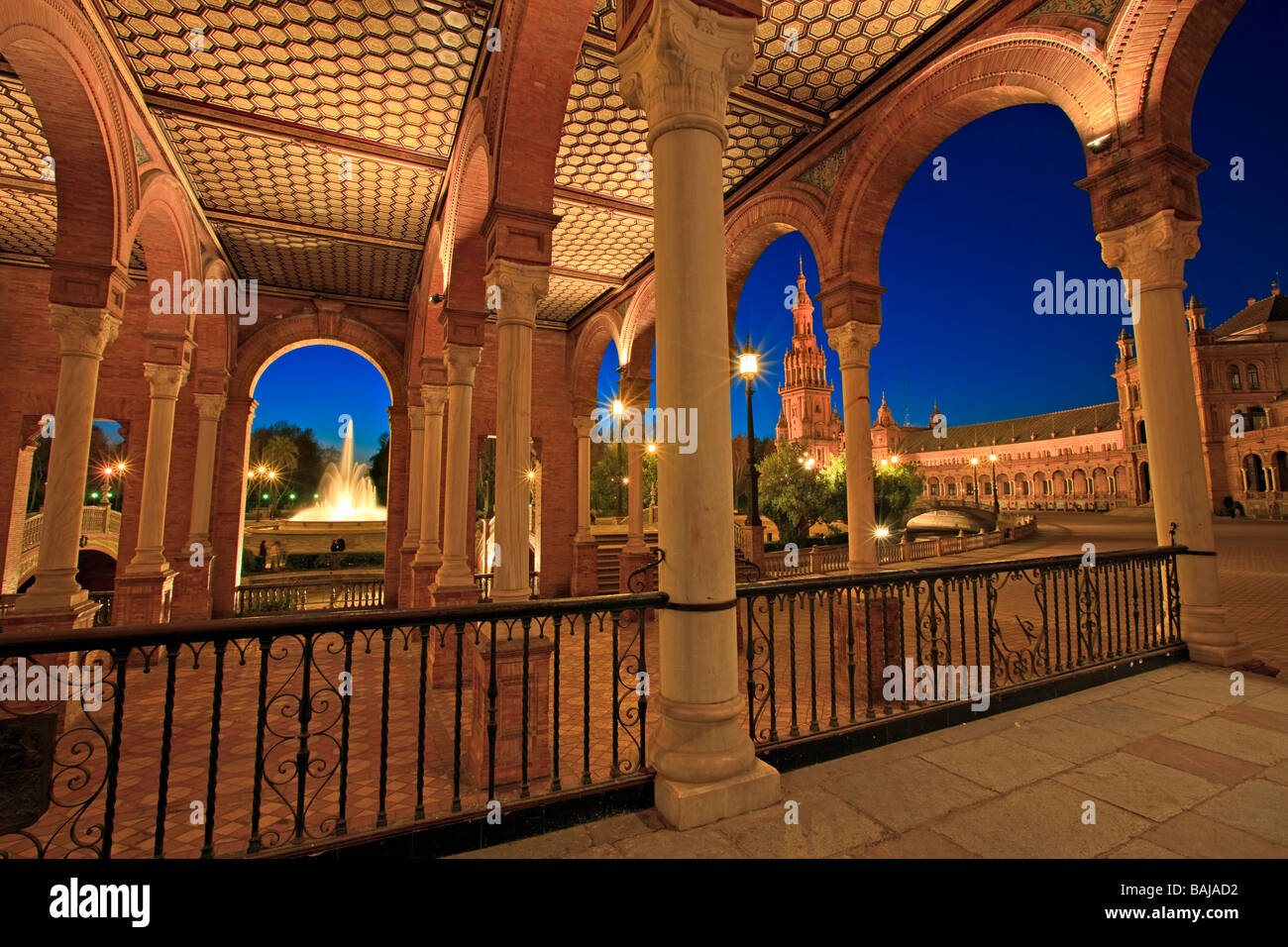 Blick auf den Brunnen aus dem zentralen Gebäude in Plaza de España, Parque Maria Luisa, in der Abenddämmerung in der Stadt Sevilla (Sevilla) Stockfoto