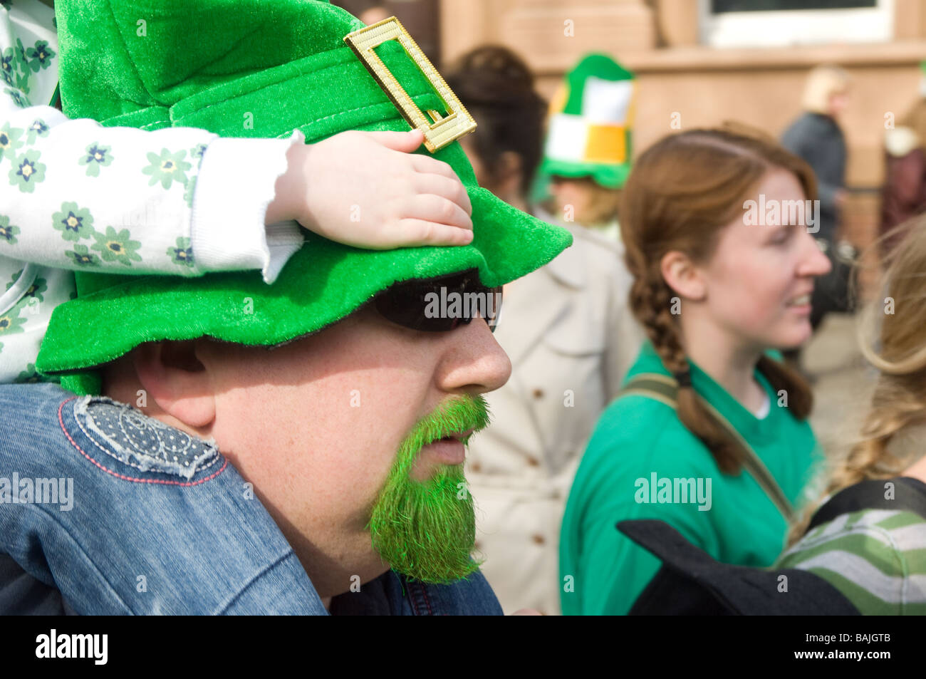 Vater mit grünen Bart mit Kind auf Schultern bei bei St Parick Tagesparade, Dublin, Irland Stockfoto