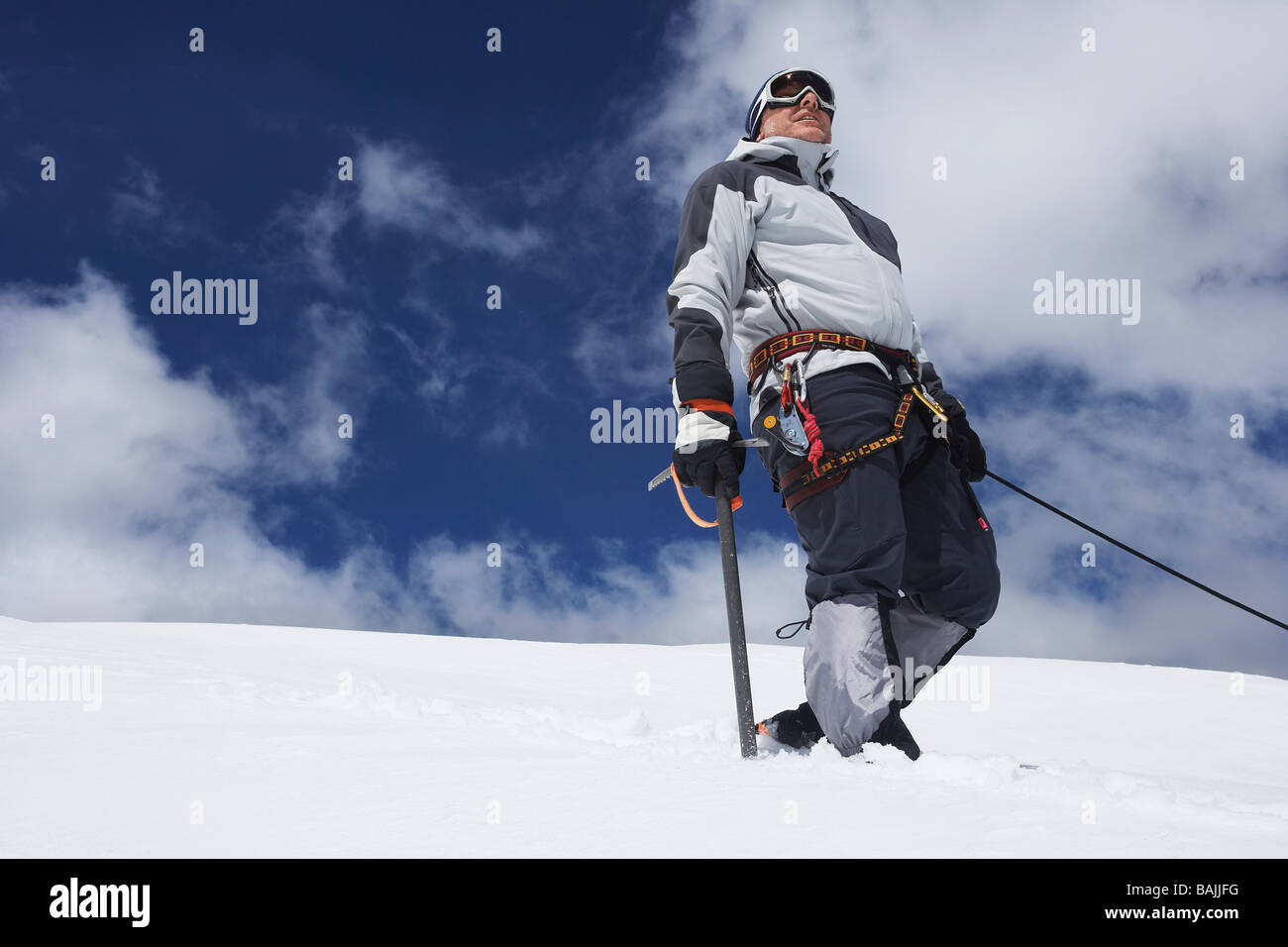 Bergsteiger auf verschneiten Hang stehend mit Sicherheitsleine verbunden Stockfoto