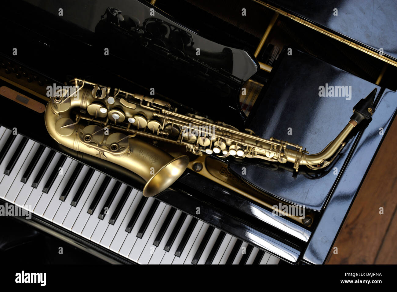 Alt-Saxophon liegend auf einem Grand piano Stockfoto