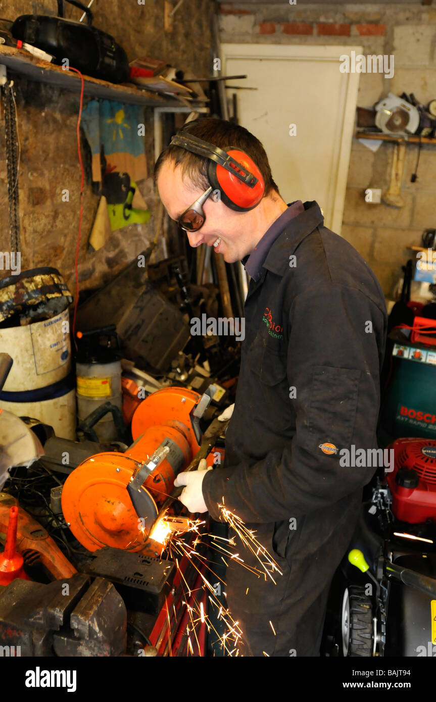 Ein Mann repariert ein Rasenmäher Messer in seiner Werkstatt Stockfoto